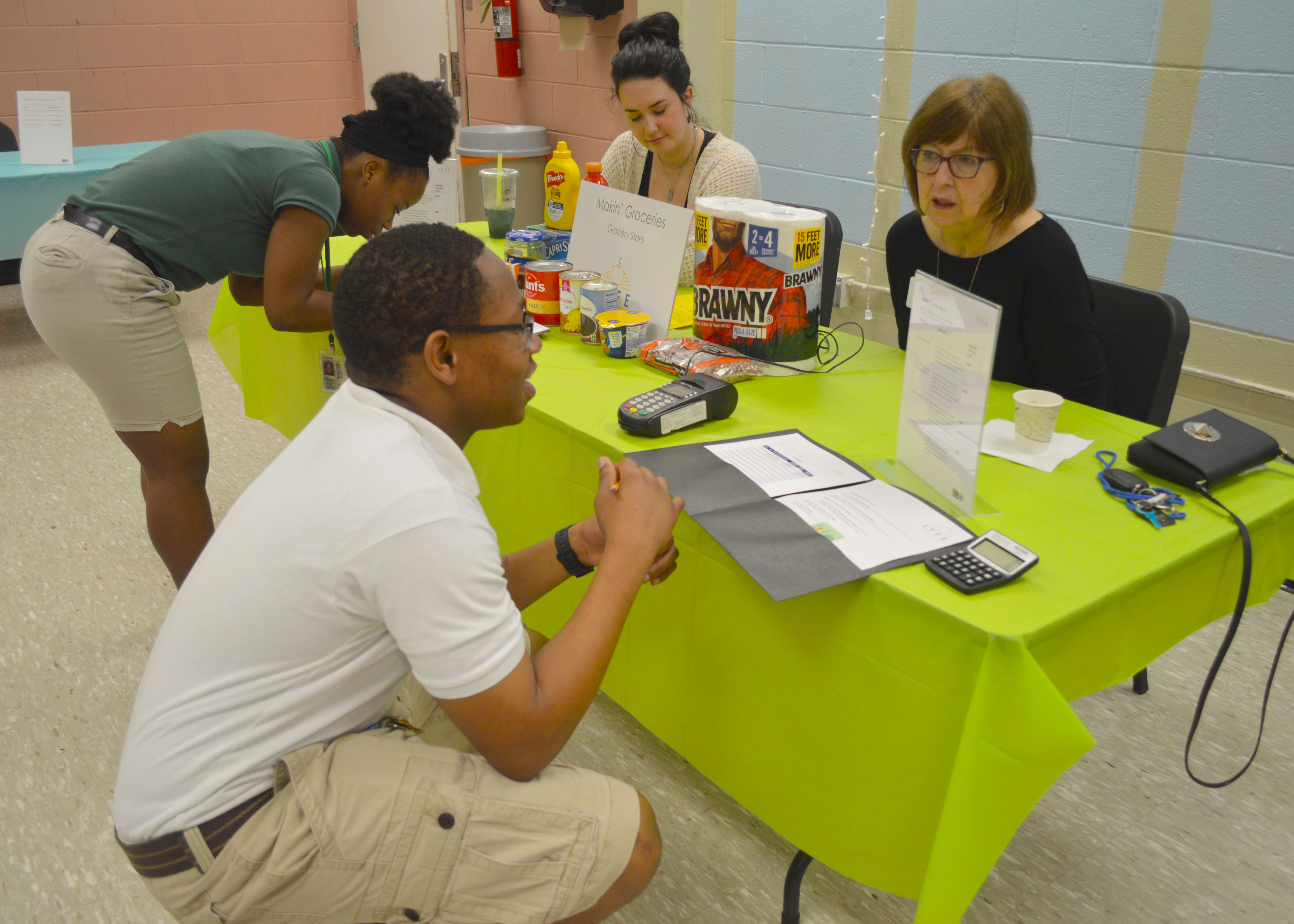 2 high school students discuss budgeting with 2 volunteers.jpg thumbnail